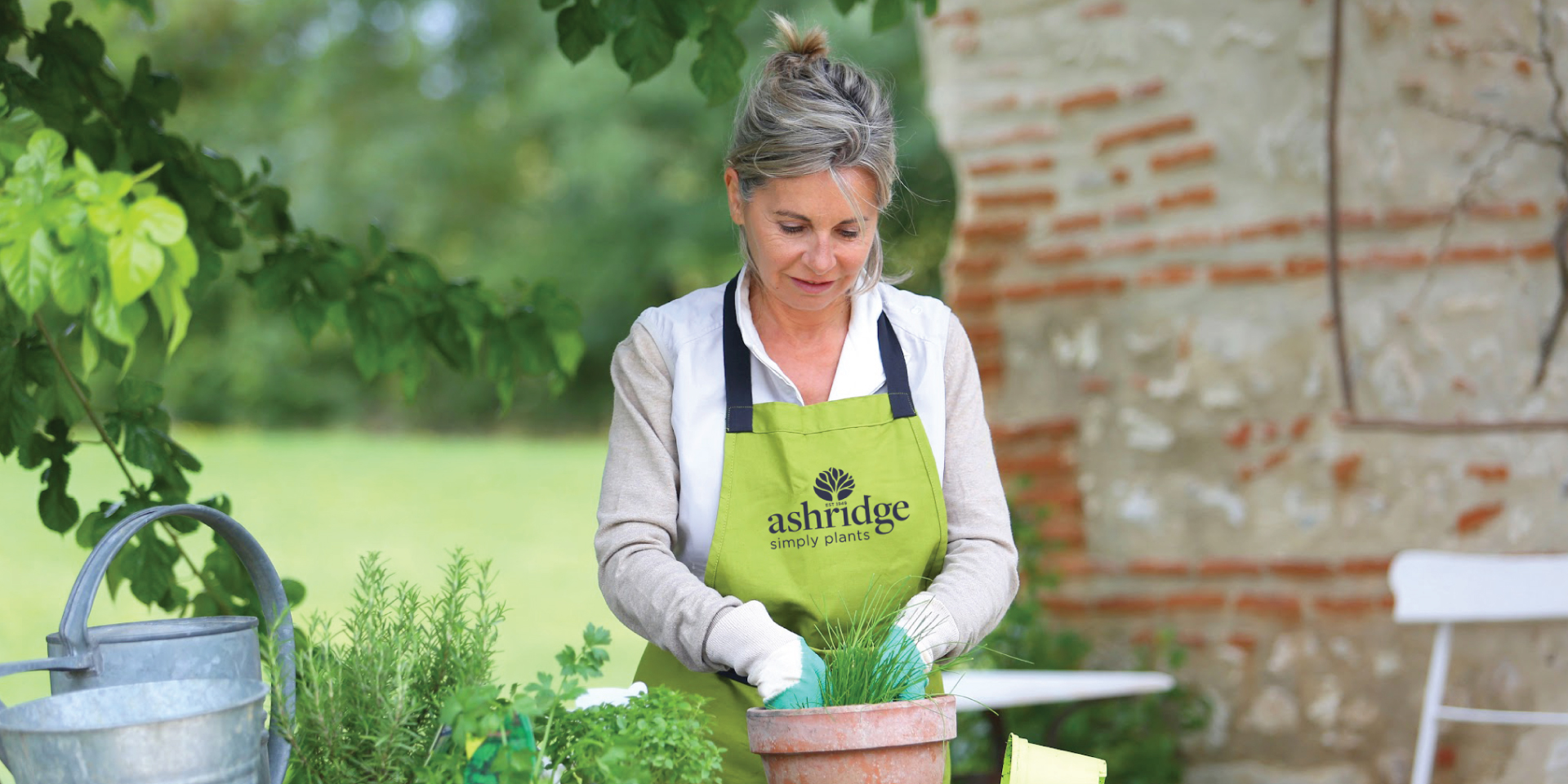 Ashridge potting plants in branded apron
